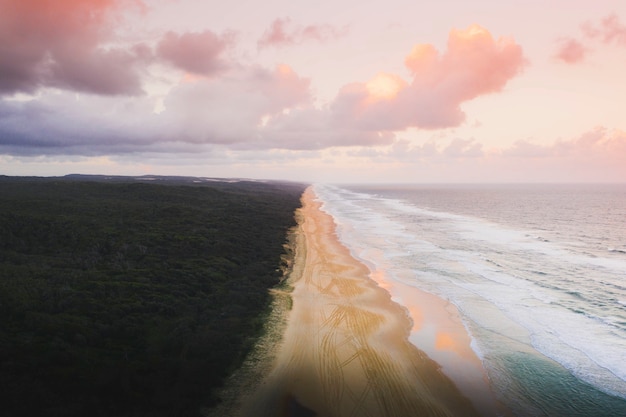 Drone vista de la costa bajo un cielo rosa pastel