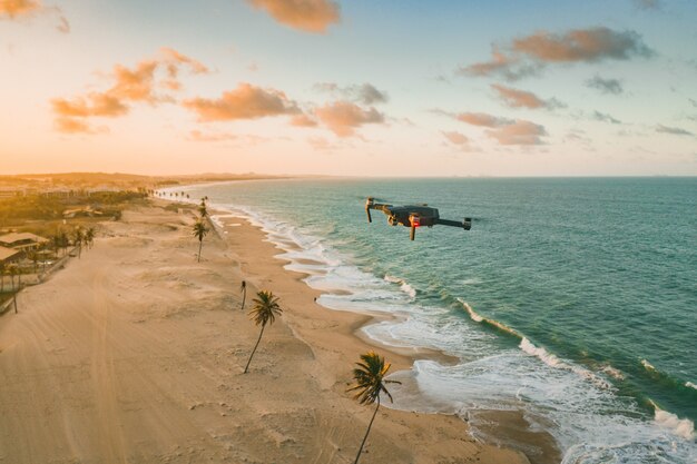 Drone volando sobre el mar y la playa.