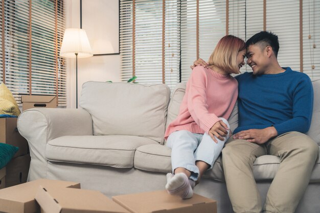 Dulce feliz joven pareja asiática moviendo ropa y muchos objetos de la antigua casa a su nuevo hogar