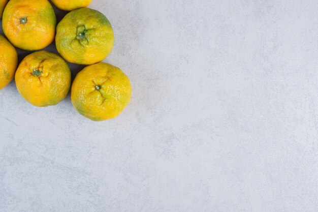 Dulce mandarina orgánica fresca sobre fondo gris.