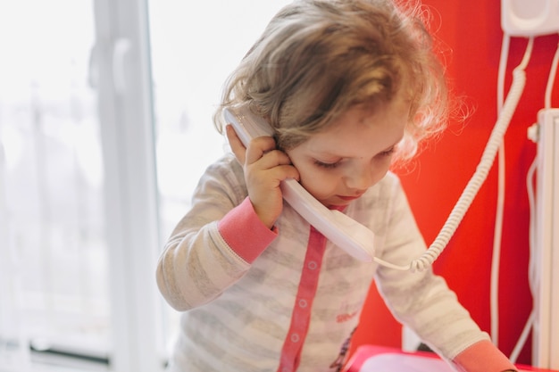 Foto gratuita dulce niña hablando por teléfono