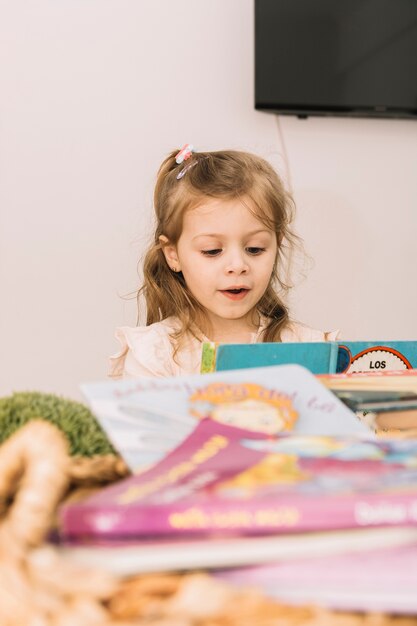 Dulce niña leyendo en la mesa