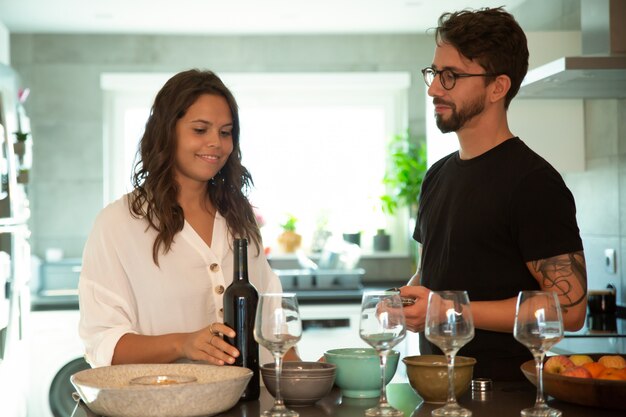 Dulce pareja cocinando y sirviendo vino