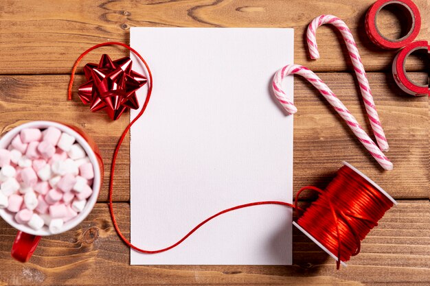 Dulces bastones de navidad y hoja en blanco