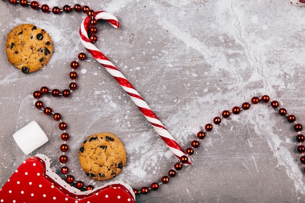 Dulces blancos rojos, galletas, malvavisco se encuentran en piso gris