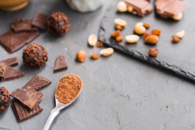 Dulces de chocolate y cuchara con cacao.