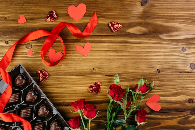 Foto gratuita dulces de chocolate con rosas en la mesa