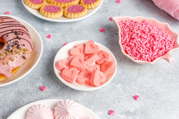 Dulces de color rosa, caramelos, merengue y azúcar.