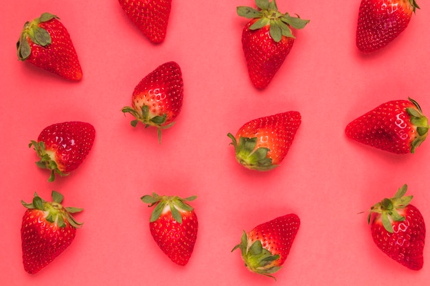 Foto gratuita dulces fresas maduras sobre fondo rosa