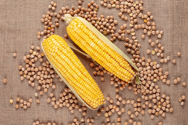 Dulces frescas mazorcas de maíz con frijoles sobre una tela de saco