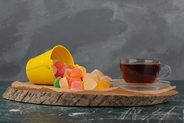 Dulces de gelatina de té aromático caliente sobre tabla de madera.