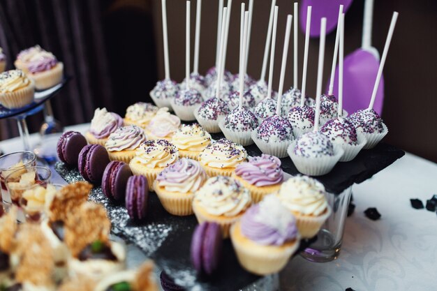 Dulces sabrosos cubiertos con esmalte violeta y blanco servido en negro