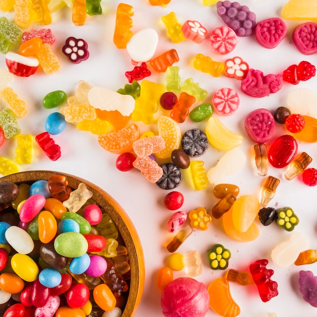 Foto gratuita dulces surtidos cerca del tazón con dulces