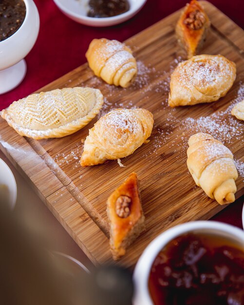 Dulces tradicionales sobre tabla de madera pakhlava shakarbura badambura mutaki vista lateral