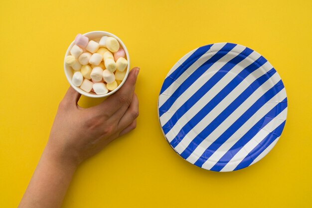 Dulces en vaso de cartón y plato