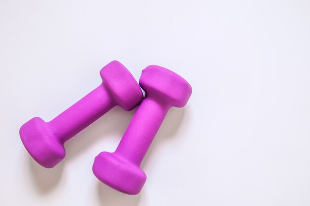 Dumbbells púrpura, concepto de fitness aislado sobre fondo blanco, concepto de fitness aislado sobre fondo blanco, el deporte, el edificio del cuerpo. Concepto estilo de vida saludable, el deporte y la dieta. Equipo de deporte. Copiar espacio