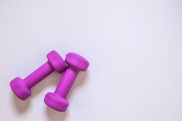 Dumbbells púrpura, concepto de fitness aislado sobre fondo blanco, concepto de fitness aislado sobre fondo blanco, el deporte, el edificio del cuerpo. Concepto estilo de vida saludable, el deporte y la dieta. Equipo de deporte. Copiar espacio