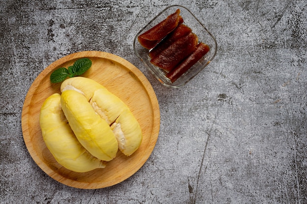 Durian y bocadillos en la superficie oscura.