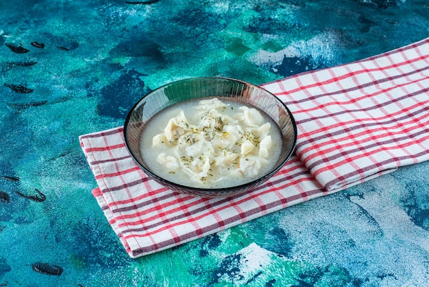 Dushbara en un plato sobre una toalla, sobre el fondo azul.