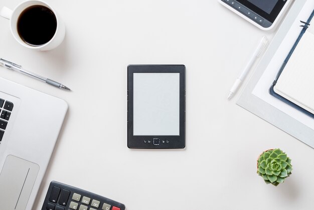 E-reader cerca de café y planta