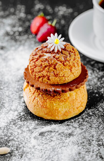 Eclair de postre francés con chocolate y una flor en la parte superior.