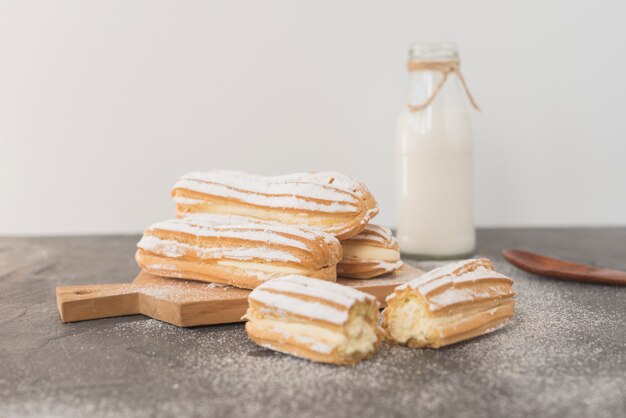 Eclairs caseros tradicionales con botella de leche.