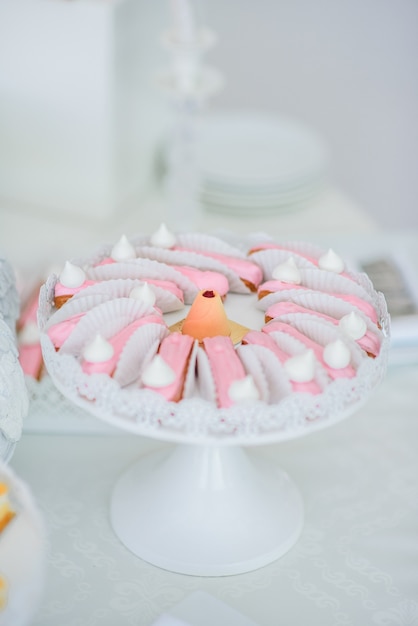 Foto gratuita eclairs cubiertos con glaseado rosa servido en plato blanco redondo