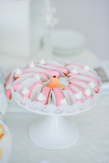 Eclairs cubiertos con glaseado rosa servido en plato blanco redondo