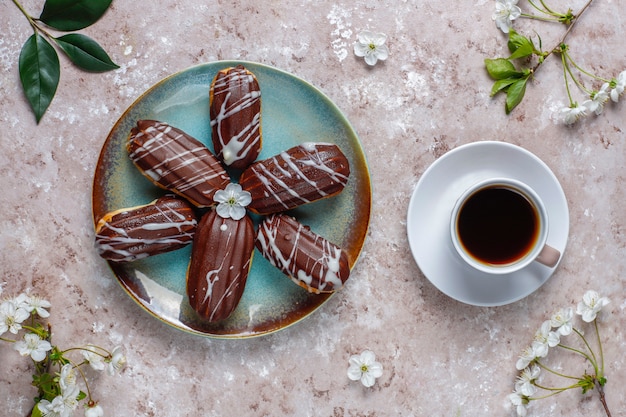 Eclairs o profiteroles con chocolate negro y chocolate blanco con natillas dentro, postre francés tradicional. vista superior.