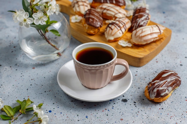 Eclairs o profiteroles con chocolate negro y chocolate blanco con natillas dentro, postre francés tradicional. Vista superior.