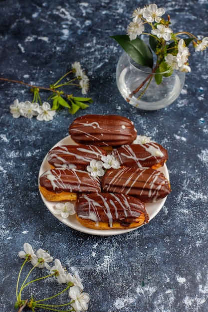 Eclairs o profiteroles con chocolate negro y chocolate blanco con natillas en el interior, postre tradicional francés.