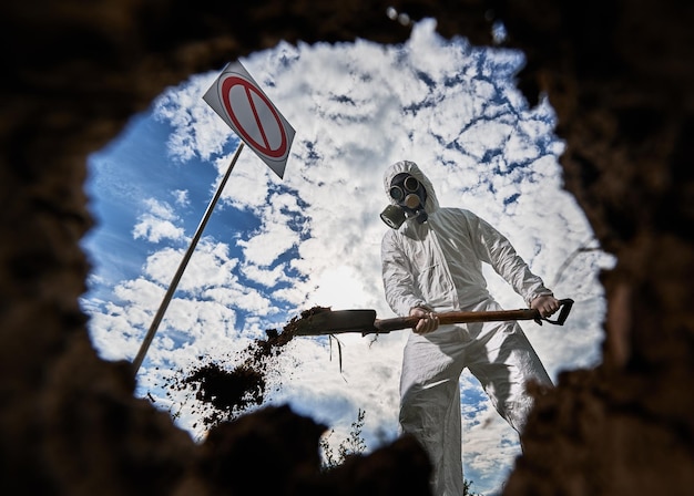 Ecologista cavando pozos con pala y plantando árboles en áreas contaminadas