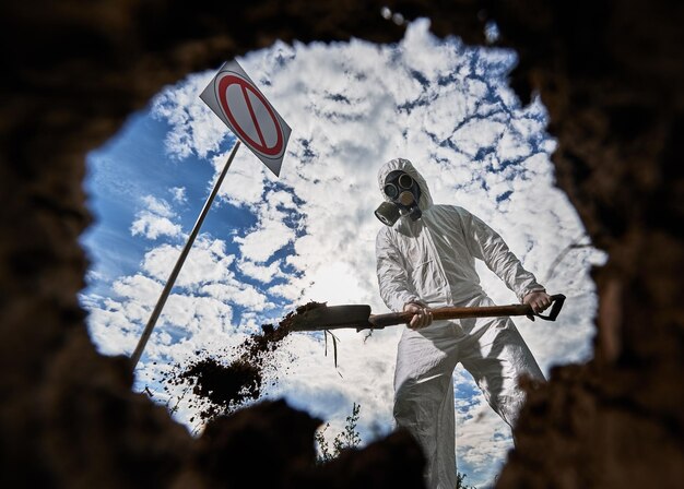 Ecologista cavando pozos con pala y plantando árboles en áreas contaminadas