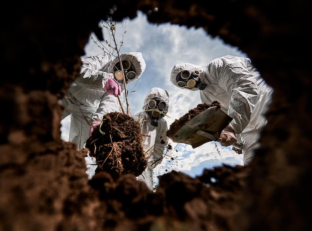 Foto gratuita ecologistas cavando pozos con pala y plantando árboles en áreas contaminadas