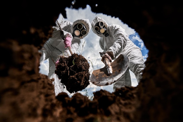 Foto gratuita ecologistas cavando pozos con pala y plantando árboles en áreas contaminadas