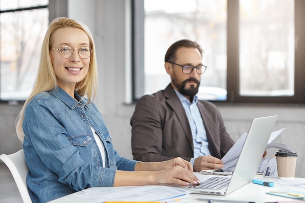 Los economistas masculinos y femeninos trabajan con documentos y tecnologías modernas.