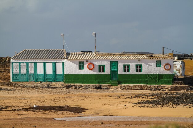 Edificio blanco y verde en medio de un campo en Fuerteventura