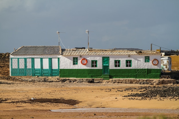 Edificio blanco y verde en medio de un campo en Fuerteventura