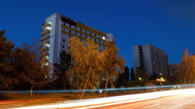 Edificio y camino con árboles por la noche.