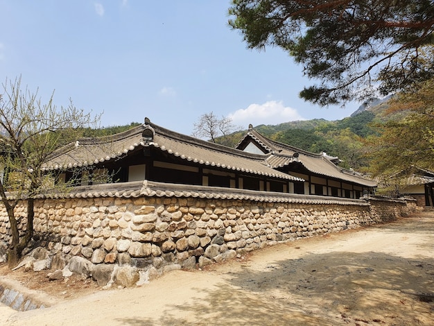 Edificio coreano rodeado de montañas bajo un cielo azul