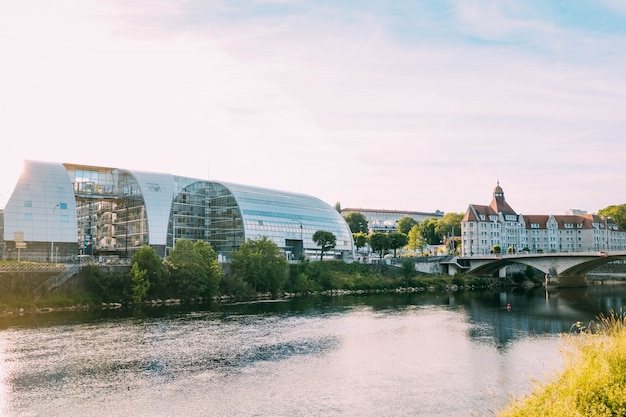 Edificio de cristal moderno y un edificio antiguo junto a un hermoso canal