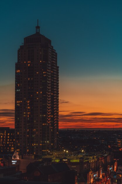 edificio de gran altura con un cielo naranja y azul