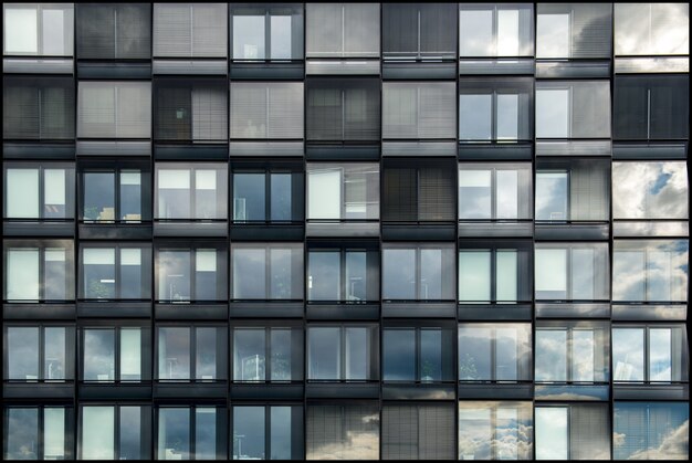 Edificio moderno con ventanas de cristal que reflejan la belleza del cielo.