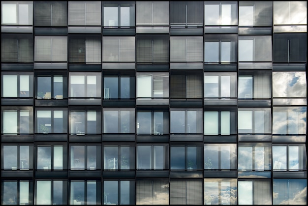 Edificio moderno con ventanas de cristal que reflejan la belleza del cielo.