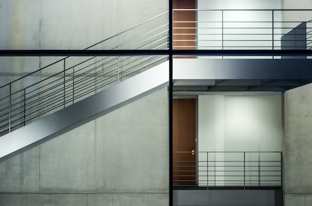 Edificio moderno con ventanas de vidrio y escaleras bajo las luces.