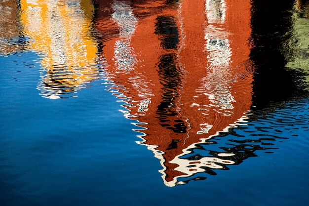 Edificio rojo y amarillo que se refleja en el lago