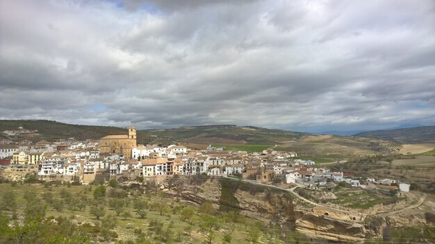 Edificios uno al lado del otro en una montaña durante el día rodeados de árboles y vegetación