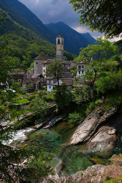 Foto gratuita edificios cerca de ríos, árboles y rocas durante el día.