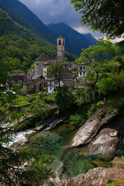 Edificios cerca de ríos, árboles y rocas durante el día.