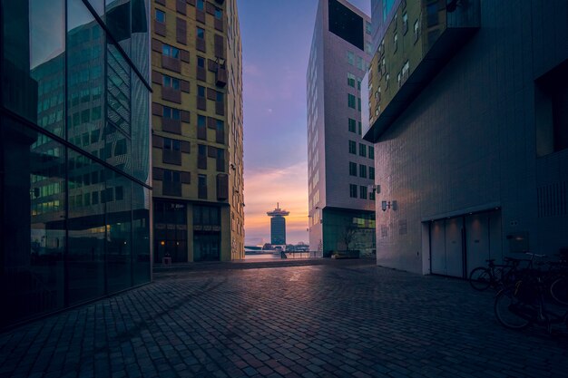 Edificios modernos con ventanas de vidrio bajo un cielo nublado durante la puesta de sol por la noche